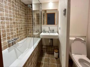 een badkamer met een wastafel, een bad en een toilet bij Résidence Grand Bois A1124 Clés Blanches in La Tania +16 foto's