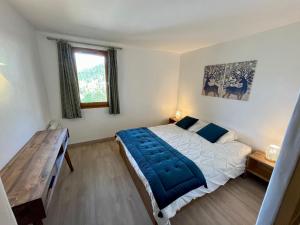 een slaapkamer met een groot bed en een houten tafel bij Résidence Grand Bois A1124 Clés Blanches in La Tania