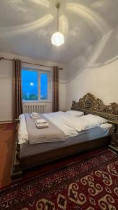 a bedroom with a large bed with a large window at Гостевой дом “Kyzyl Alma” (Red Apple) in Chon-Dzhargylchak