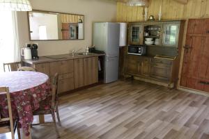eine Küche mit Holzboden und einem Kühlschrank und einem Tisch in der Unterkunft Latava in Anykščiai