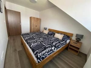 een slaapkamer met een bed met een zwart-wit dekbed bij Černá růže - Apartmán 5 in Pilsen