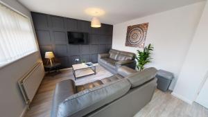 uma sala de estar com um sofá e uma televisão em Flexley House Workstays UK em Middlesbrough
