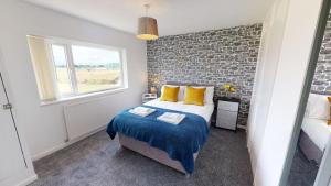 ミドルズブラにあるFlexley House Workstays UKのベッドとレンガの壁がある寝室 +16枚の写真