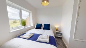 Duas camas num pequeno quarto com uma janela em Flexley House Workstays UK em Middlesbrough