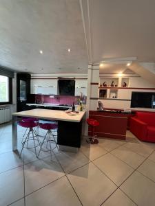 a kitchen with a large island and red chairs at Garda Art&Garden in Volta Mantovana