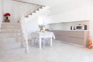 a kitchen and dining room with a table and a staircase at FONTE D'OLIO CONERO RELAIS in Sirolo