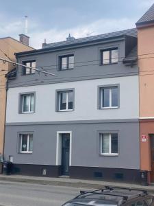 a white building with a blue door on a street at Černá růže - Apartmán 5 in Pilsen