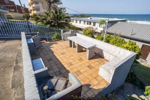 a bench sitting on a patio next to the ocean at Breathtaking views from Sue Casa 11 in Margate +7 photos
