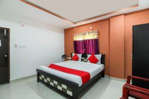 een slaapkamer met een bed met rode en witte lakens bij New Cyber Grand Madhapur in Kondapur