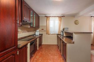 a large kitchen with wooden cabinets and counters at Pool Villa Divina - Happy Rentals in Šišan