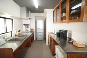 eine Küche mit einer Spüle und einem Kühlschrank in der Unterkunft Tabiyu Abrigo in Kōbe