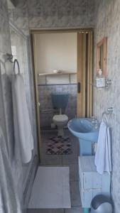 a bathroom with a toilet and a sink at Bluewater Reservations in Port Elizabeth