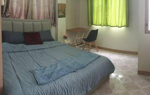 a bedroom with a bed and a table and a chair at JATUPORN A3 in Ban Talat Rangsit