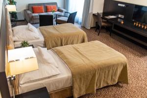 a hotel room with two beds and a couch at Hotel Avance in Bratislava