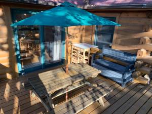 a wooden bench on a deck with an umbrella at Place yatsugatake Oigamori cottage - Vacation STAY 93259v in Hokuto