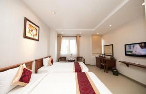 クアローにあるChâu Giang Hotel Cửa Lòのベッド2台、薄型テレビが備わるホテルルームです。