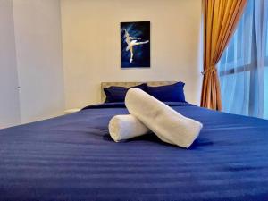 a bedroom with a blue bed with a pillow on it at Citrine Hub in Sunway Iskandar by Cowidea in Kampong Pendas