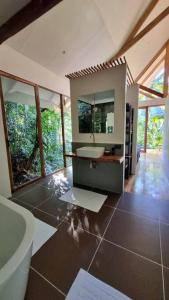 a bathroom with a tub and a sink and a mirror at Remote Home near Secret Lagoon with Motorcycle in Siquijor