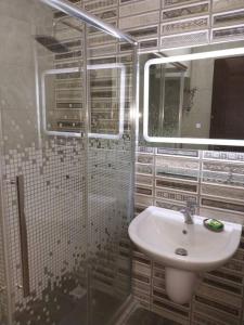 a bathroom with a sink and a mirror at Adam's Apartment in Amman