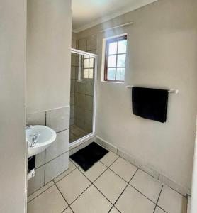 a bathroom with a shower and a sink at The Eden Boulders Hotel and Resort Midrand in Midrand