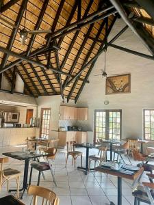 a large room with tables and chairs and a kitchen at The Eden Boulders Hotel and Resort Midrand in Midrand