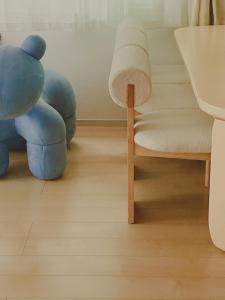 湘南民泊kabigon في Chigasaki: غرفة معيشة مع دمية الدب يجلس بجوار كرسي
