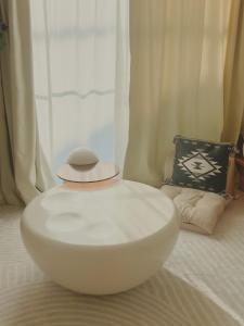 una ciotola bianca su un letto con un cappello sopra di 湘南民泊kabigon a Chigasaki
