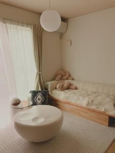 湘南民泊kabigon في Chigasaki: غرفة نوم بسرير مع كرسي وطاولة