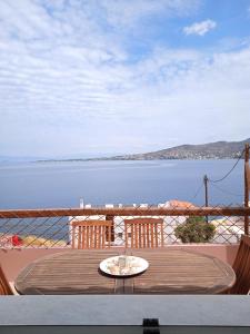 a table on a balcony with a view of the water at Calma in Perdika