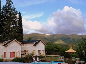 a white house with a view of a mountain at Altos del Pucará Piscina Climatizada Juegos infantiles Huerta Orgánica in Huerta Grande