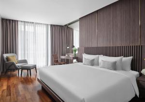 un grande letto bianco in una camera d'albergo di Fraser Suites Sukhumvit Bangkok a Bangkok