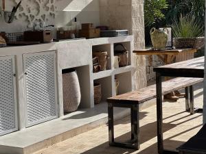 a table and bench in front of a counter at Il Saraceno B&B in Carovigno