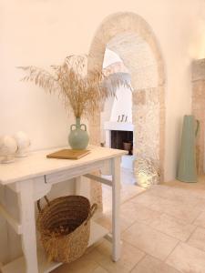 a table with a vase on it in a room at Borgo Petra - with heated pool in Cisternino