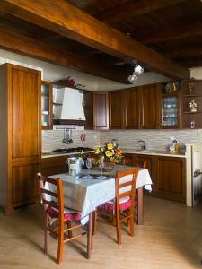 una cocina con mesa y algunas sillas y una cocina con en Oasi Rubino, en Nettuno