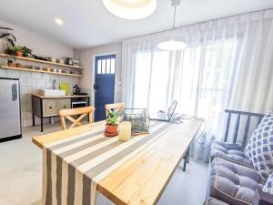 Snoozy Guesthouse في فوكيت تاون: مطبخ وغرفة معيشة مع طاولة خشبية