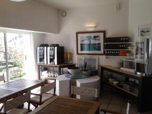 een keuken met een tafel en stoelen en een magnetron bij Hôtel L'Escale in L'Ile d'Yeu