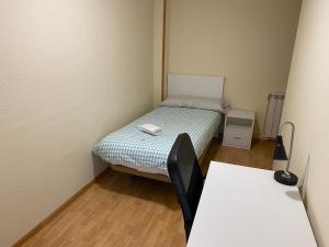 Habitación pequeña con cama y mesa en Room in Guest room - H Individual In Reformed Residence has wifi center num102, en Madrid