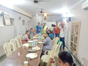 a group of people sitting around a long table at Scindhia Guest House in Varanasi