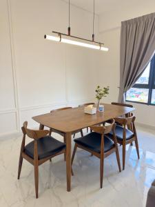 a dining room table with two chairs and a wooden table at Troika Kota Bharu Penthouse Homestay in Kota Bharu
