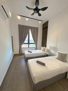 a bedroom with two beds and a ceiling fan at Troika Kota Bharu Penthouse Homestay in Kota Bharu