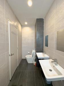 a bathroom with two sinks and a toilet at Troika Kota Bharu Penthouse Homestay in Kota Bharu