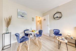 sala de estar con sillas azules y mesa en Le Cocon/10 min de Paris, RER A à 4 Min, en Nogent-sur-Marne