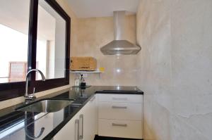 eine kleine Küche mit Spüle und Spiegel in der Unterkunft Casa Paloma in San José + 24 Fotos