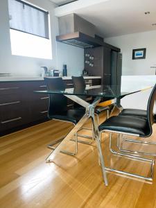 a kitchen with a glass table and black chairs at 47 Breathtaking City Riverviews 2brpark in Perth