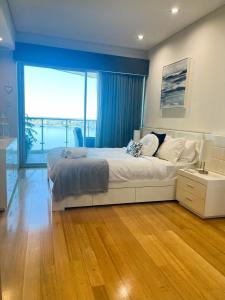 a bedroom with a large bed and a large window at 47 Breathtaking City Riverviews 2brpark in Perth