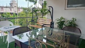 d'un balcon avec une table, des chaises et un banc. dans l'établissement 7 Sisters Homestay, à Guwahati