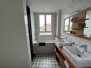 a bathroom with two sinks and a bath tub at Coeur de ville , 70m2 , 2 chambres in Saint-Brieuc