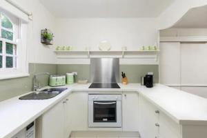 a white kitchen with a sink and a stove at Chestnut Tree Holiday Units in Bright