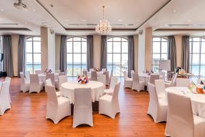 um quarto com mesas e cadeiras brancas e um lustre em Sea Breeze Hotel & Villa em Sihanoukville