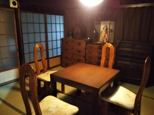 een eetkamer met een houten tafel en stoelen bij 御師の家　梅谷（UMEYA） in Fujikawaguchiko